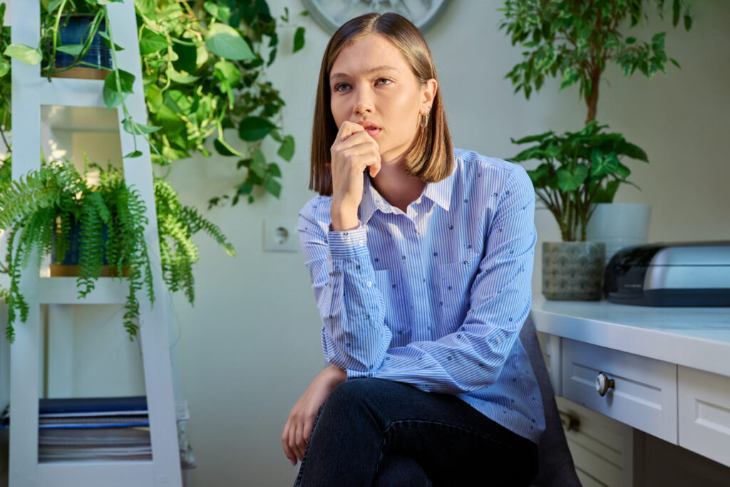 Unhappy sad upset young woman sitting alone at home. Depressed anxious lonely pensive worried 20s female. Stress, depression, emotion, problems, youth, mental health concept, divorce and sadness