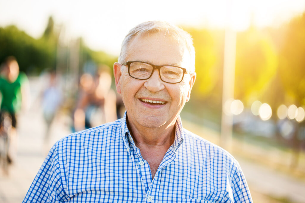 A senior who is smiling and happy after their kids figured out how to stop an elderly parent from giving money away. 
