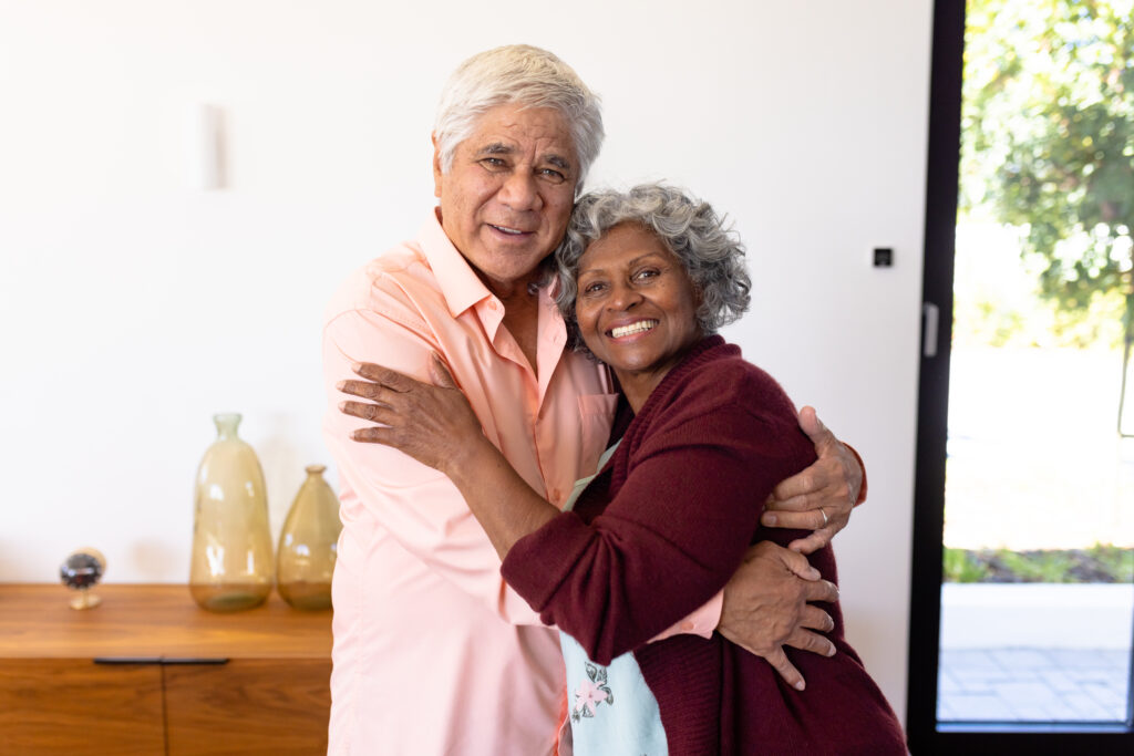 A happy senior couple smiling and relieved after they answered the question, Why would you put your house in a trust?