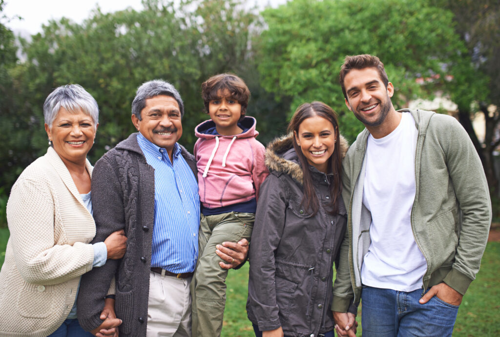 Several generations of a happy family, smiling because they learned the power of setting up a trust fund for a child.