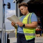 Warehouse worker reading rights booklet in warehouse