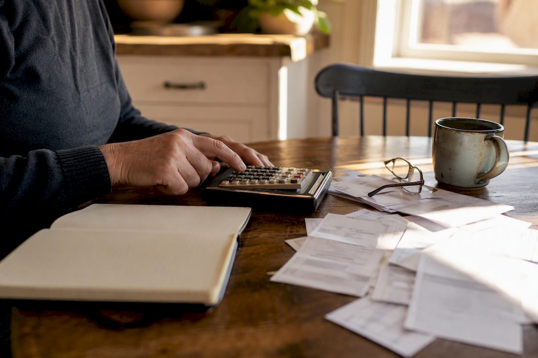 Hands calculating severance pay with calculator
